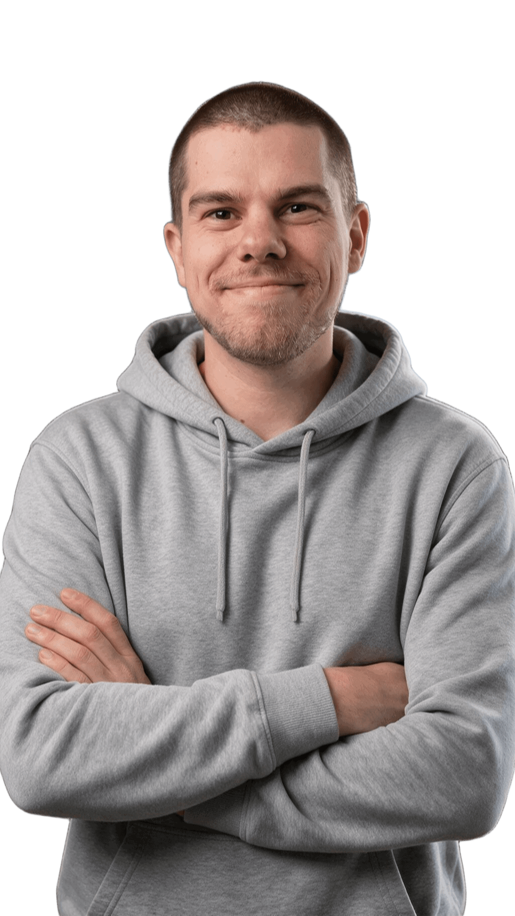 Junger Mann in grauem Hoodie mit verschränkten Armen, lächelnd.
